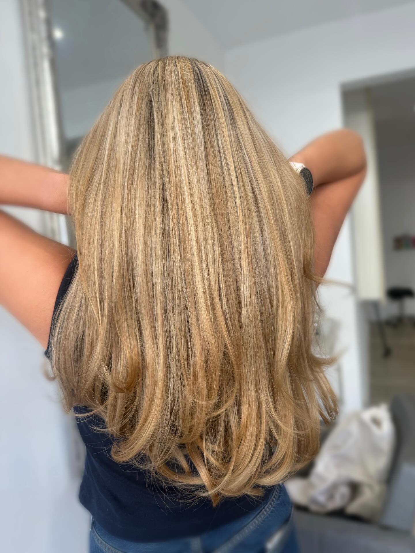 Beige blonde highlights with long layers and a smooth glossy finish.