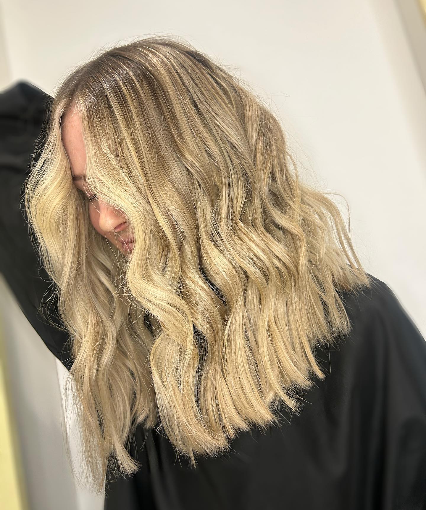 Blonde balayage long bob with soft texture and movement.