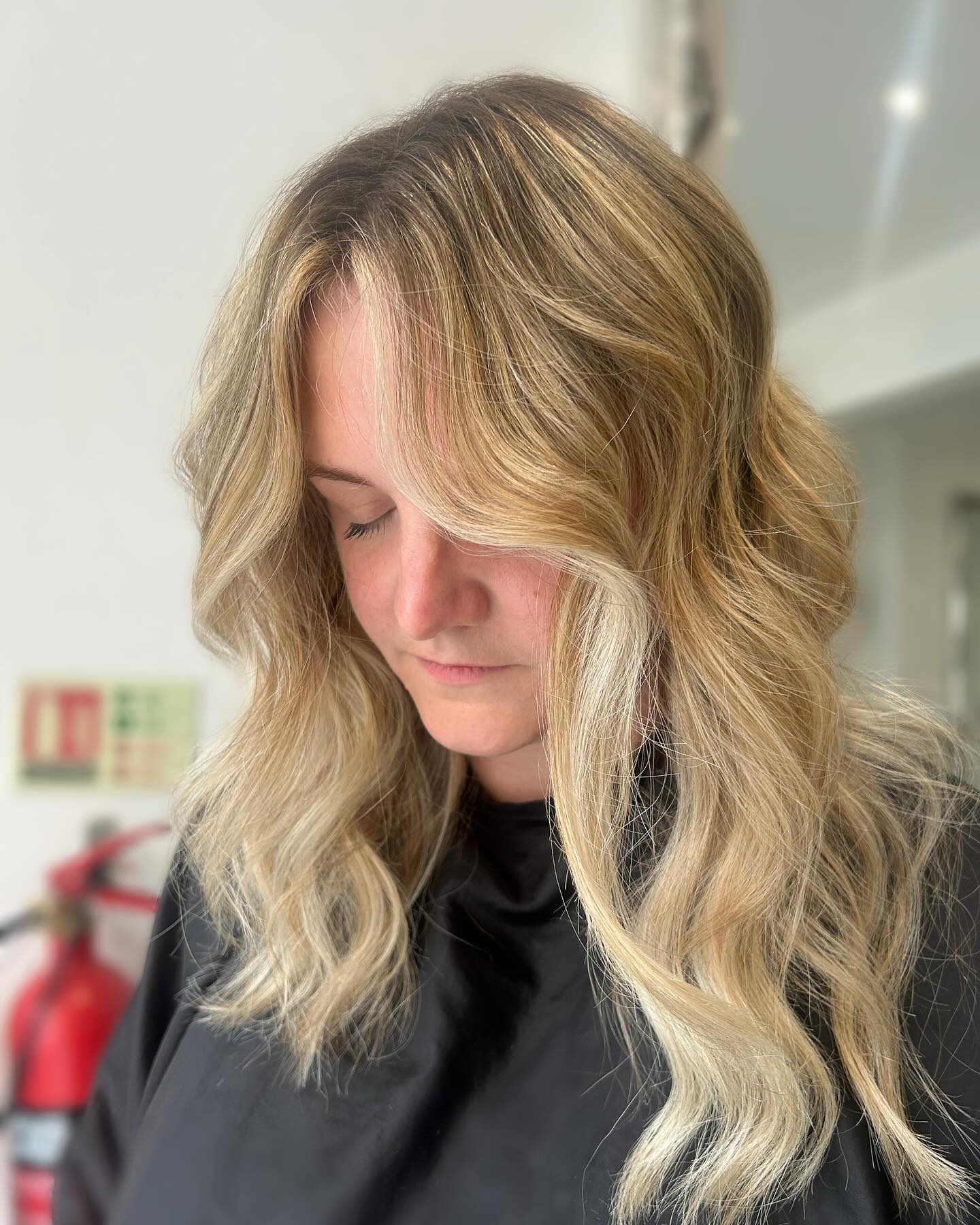 Blonde balayage with soft beachy waves and natural dimension.