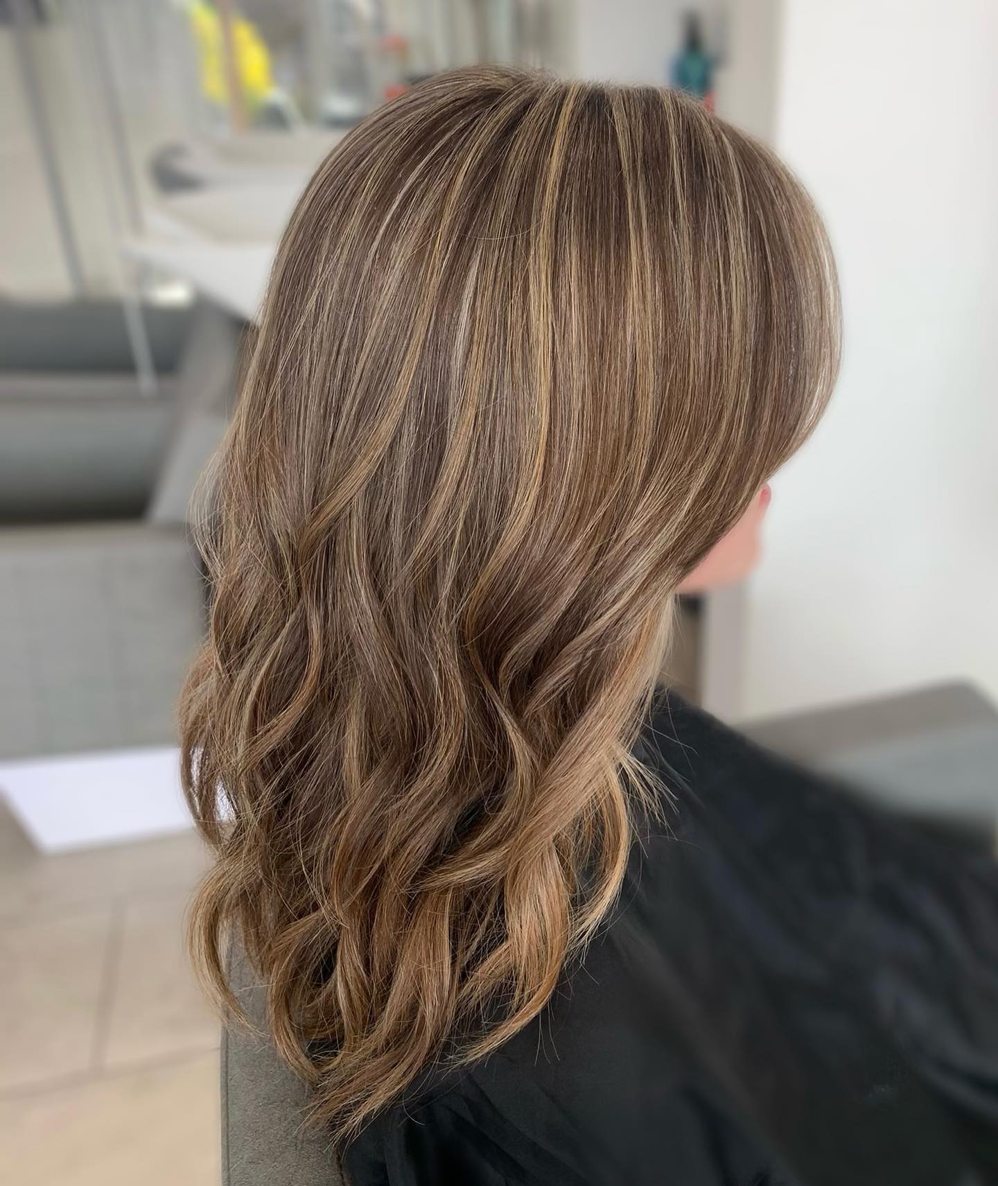 Brunette hair with caramel highlights and soft loose waves.