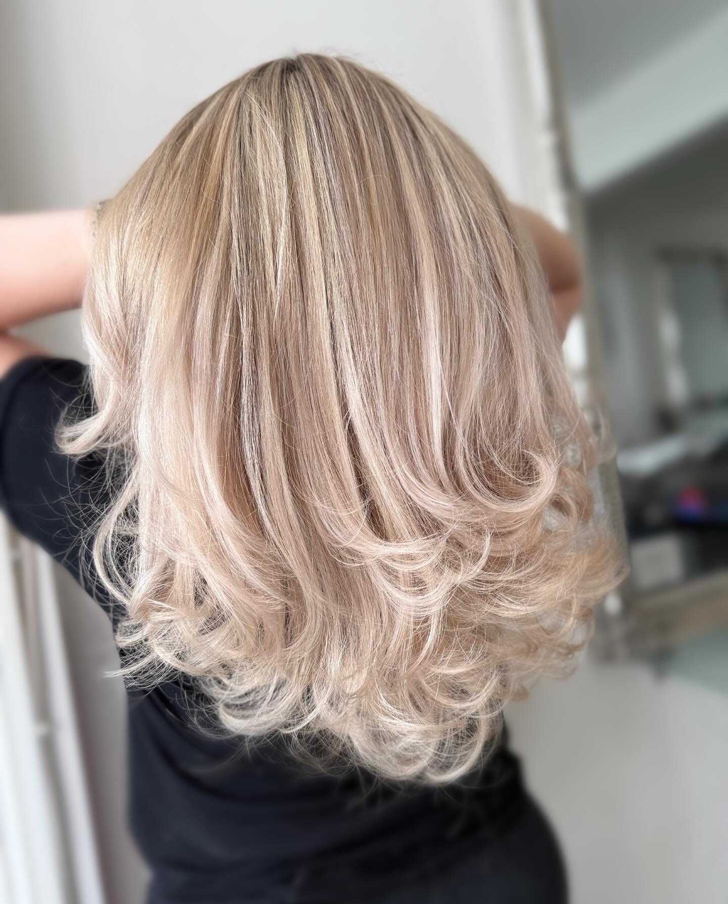 Icy blonde layered blow dry with volume and movement.