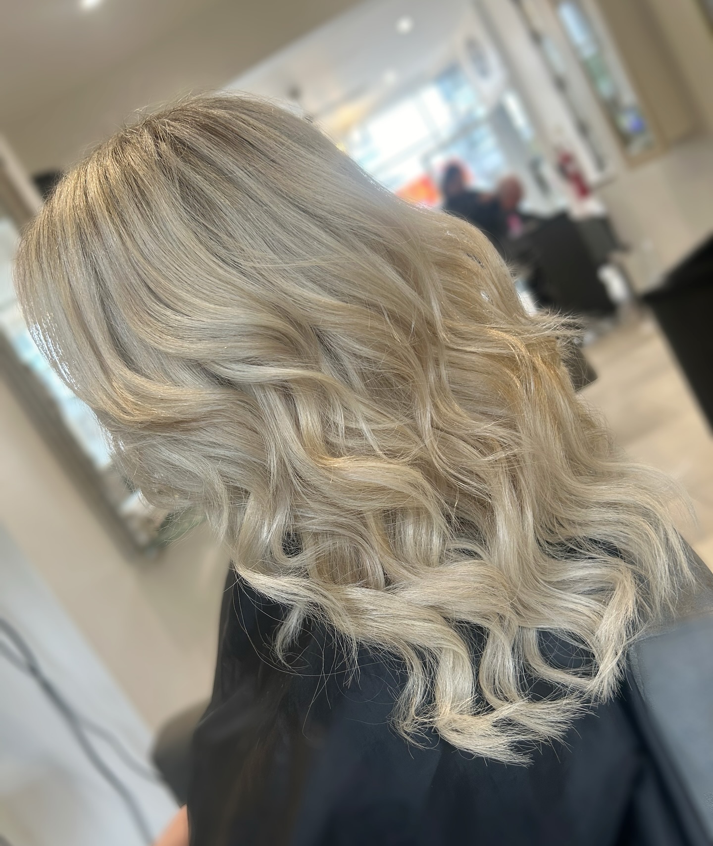 Platinum blonde hair styled with soft glamorous waves.