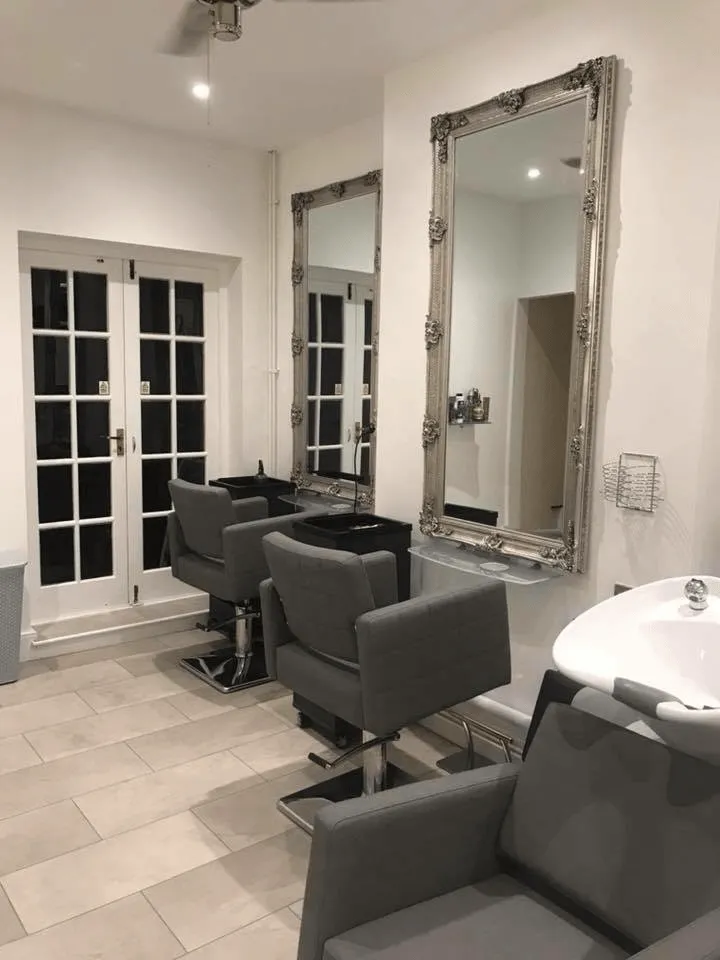 Modern Hair Obsession salon interior featuring styling stations, ornate mirrors, comfortable styling chairs and wash basins.