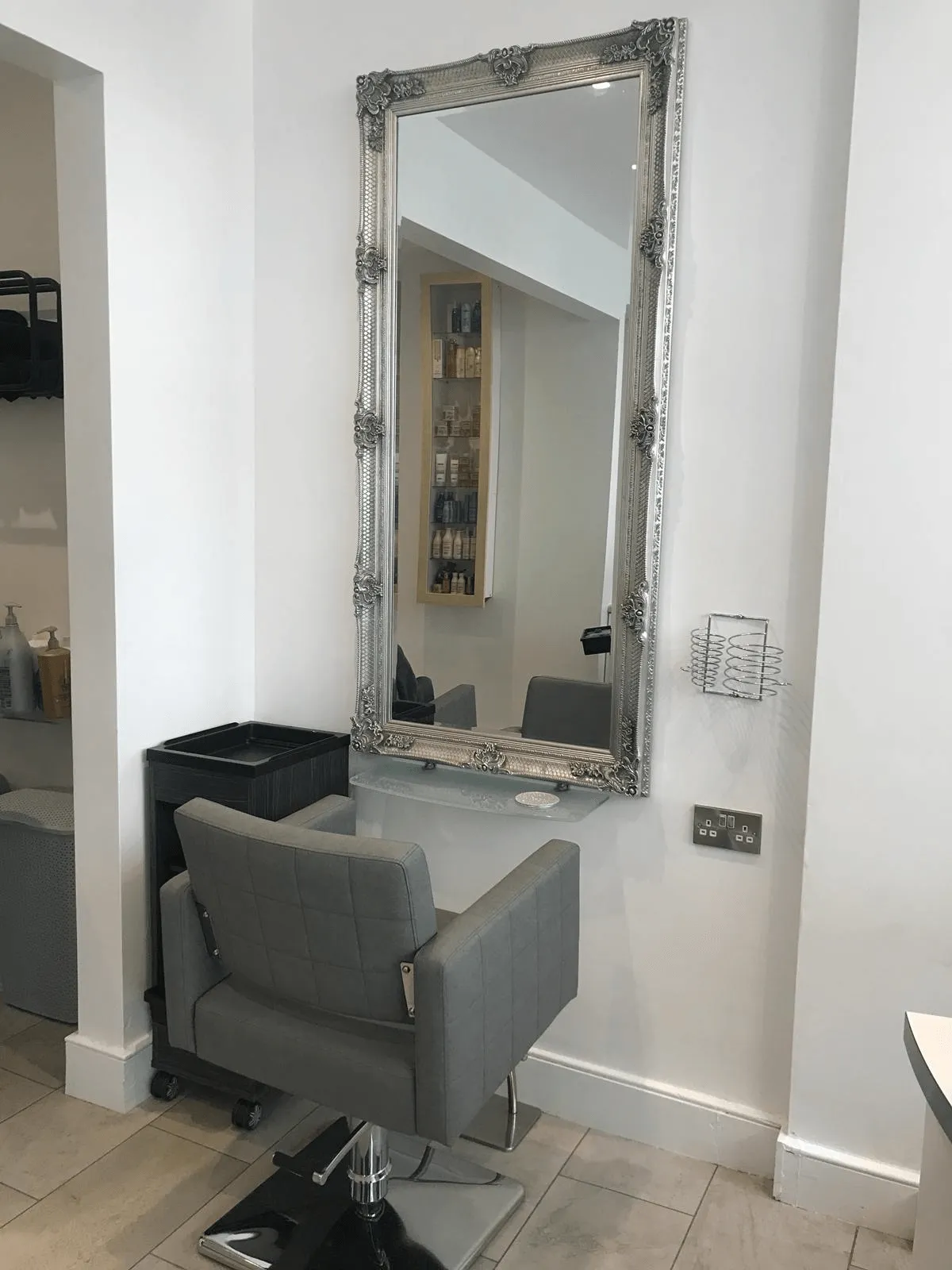 Hair styling chair and ornate salon mirror at Hair Obsession, creating a welcoming and professional salon environment.